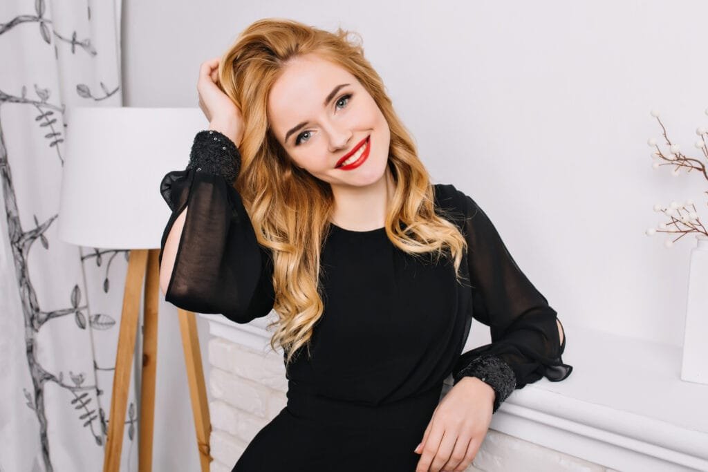 attractive-young-woman-with-beautiful-smile-sensually-touching-her-wavy-blonde-hair-white-modern-room-wearing-fashineble-black-dress-red-lipstick-light-makeup-1024x683 Jessica Chastain Hair Color